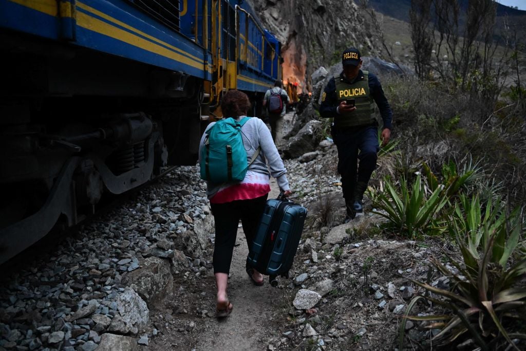 Stranded tourists who were visiting the Inca citadel of Machu Picchu walk next to the railway track after being evacuated by train to Ollantaytambo, Peru, in an earlier protest shut down last year. Photo by Martin Bernetti/AFP via Getty Images.