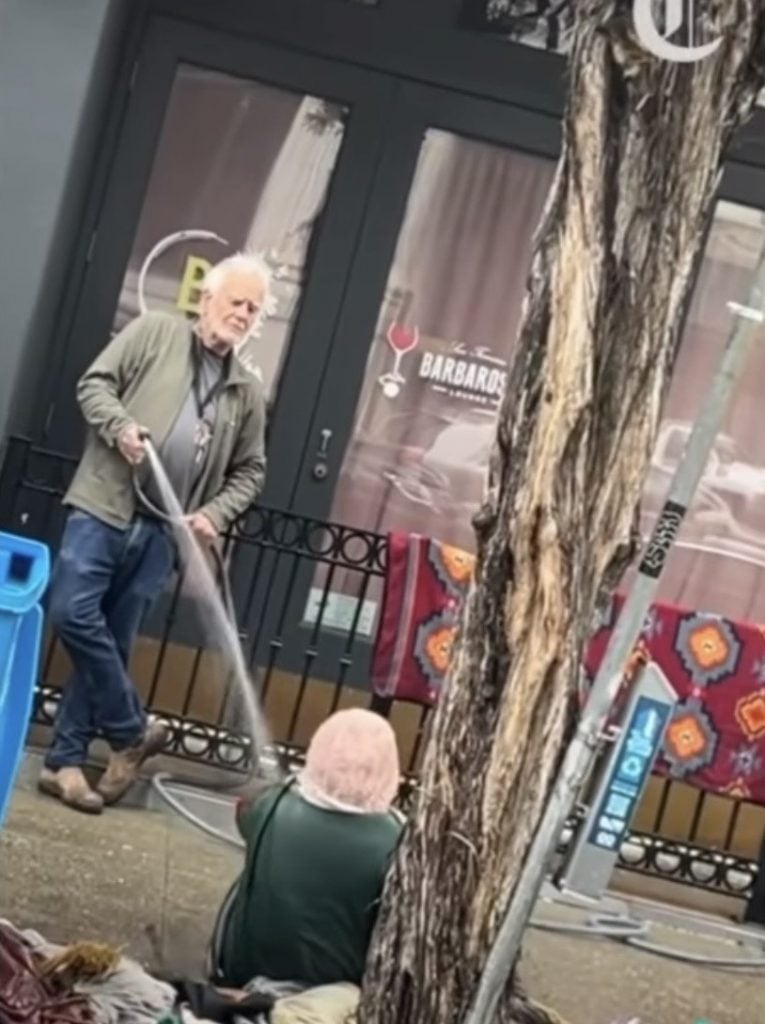 Still from a video of gallery owner Collier Gwin spraying an unhoused woman in San Francisco.