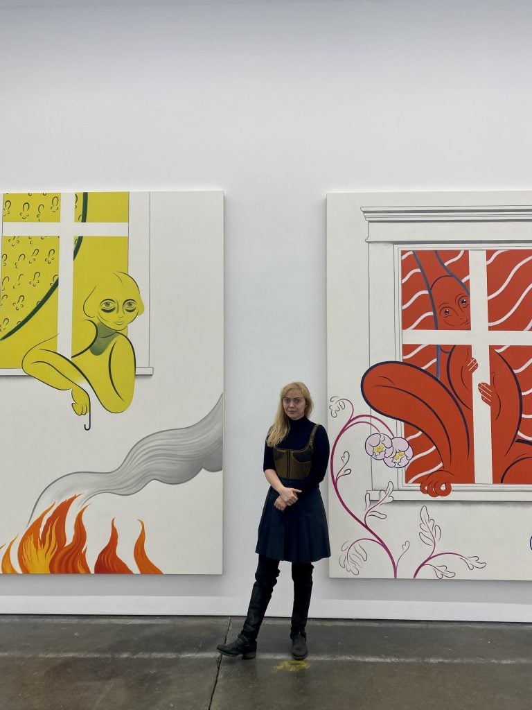 Koak with two of her paintings at her solo show at Altman Siegel in San Francisco. Photo by Sarah Cascone. 