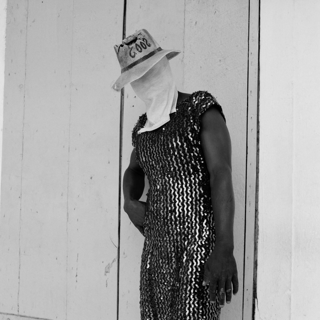 Leah Gordon, Nèg pote Wob fè Fas Kache: Deye (Man Wearing a Dress Hiding his Face: Front) (2004). Courtesy of Ed Cross, London.