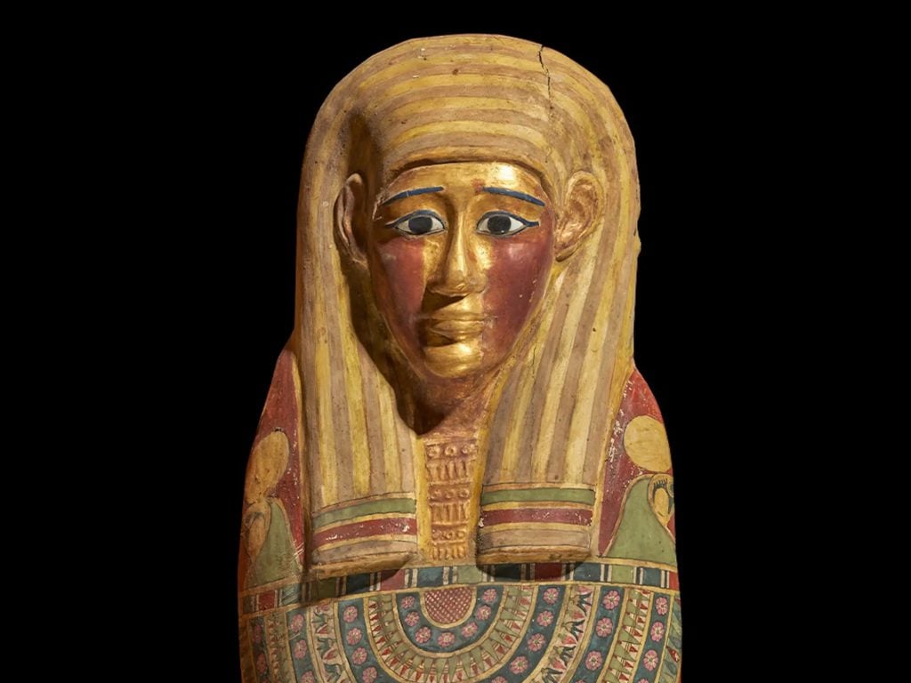 The mummy's coffin, featuring a gilded face mask. Photo: Sahar Saleem.