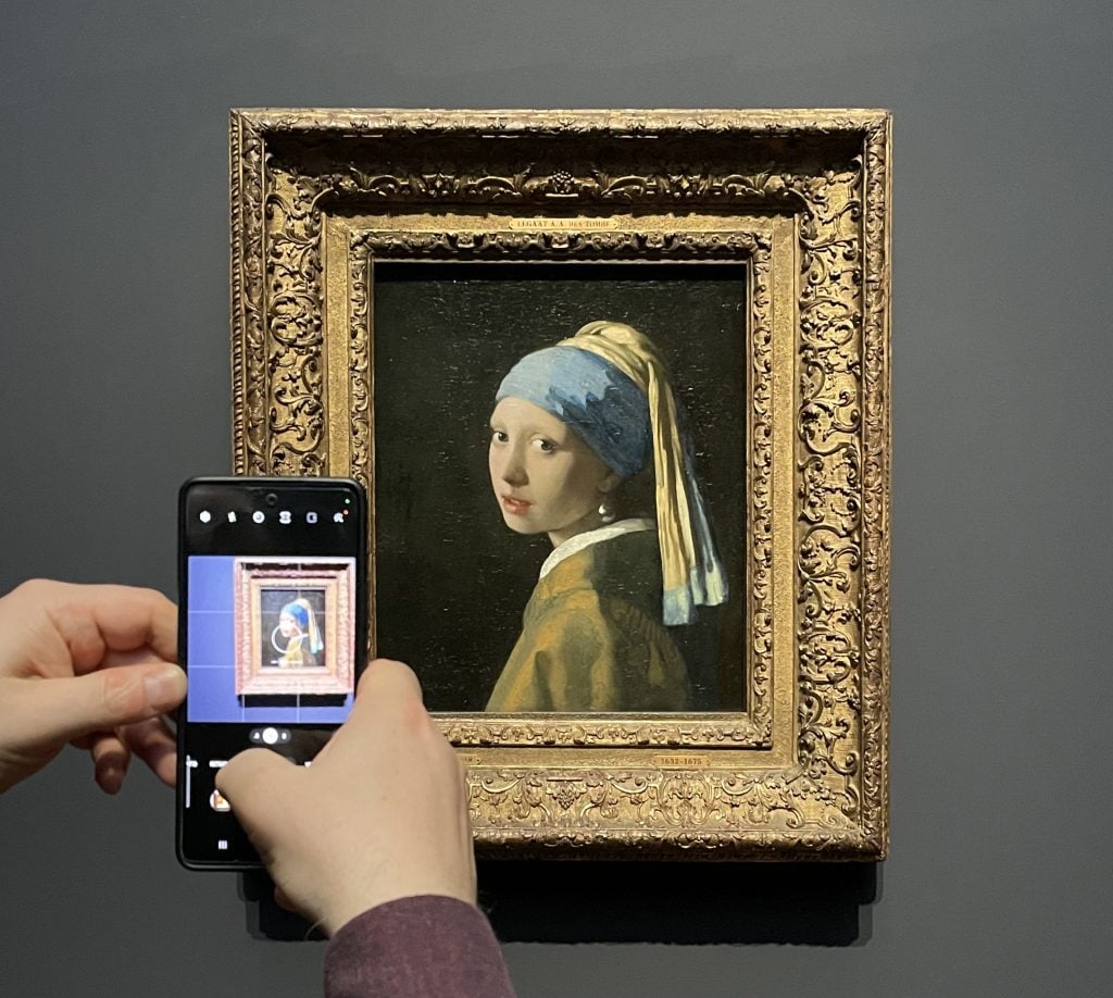 An art critic photographing Johannes Vermeer's famed Girl with a Pearl Earring during the media preview of exhibition 