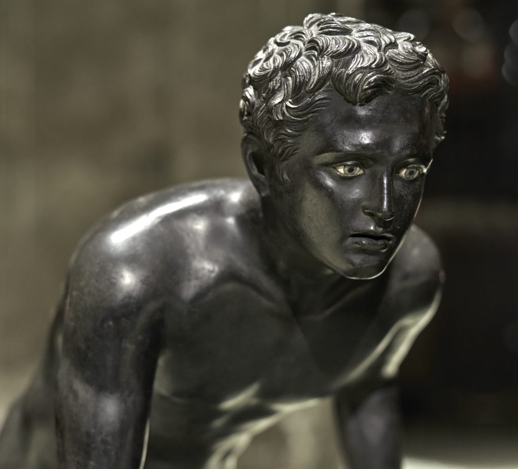 A detail of one of the ancient bronze runner statues used as the set design for Fall 2023. Courtesy of Bottega Veneta.