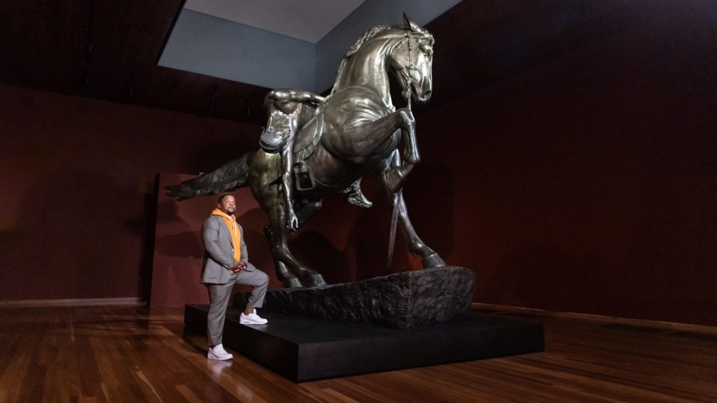 Kehinde Wiley at his exhibition "An Archaeology of Silence" with his sculpture of the same name at the de Young Museum in San Francisco. Photo by Gary Sexton, courtesy of the Fine Arts Museums of San Francisco.