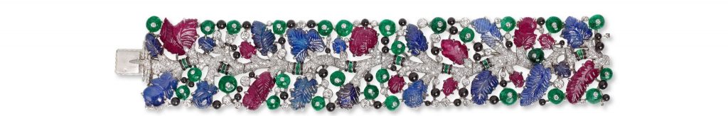 'Tutti Frutti' strap bracelet, Cartier Paris, 1925.Platinum, round old-and single-cut diamonds, leaf-shaped carved sapphires and rubies, emerald beads studded with collet-set diamonds, emerald cabochons, onyx beads (berries), black enamel. Sold to Mrs. Cole Porter. Linda Lee Thomas (1883–1954) was born in Louisville, Kentucky, and married the famous American composer Cole Porter in 1919. Considered one of the most beautiful women in the world, Mrs. Porter was a great fan of Cartier’s Tutti Frutti jewelry. Photo: Nils Herrmann, courtesy of Cartier.