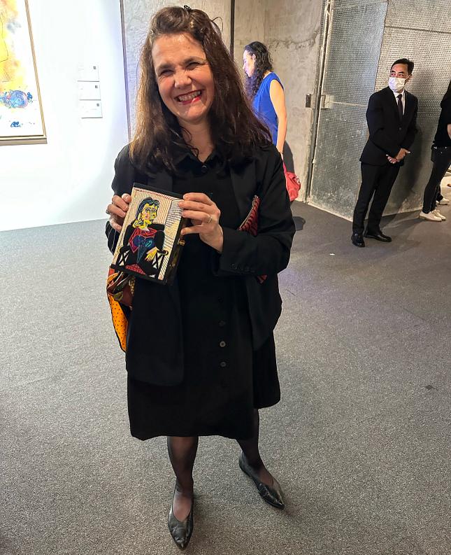 Cécile Debray the President of the Musée Picasso in Paris holding the limited edition OLT / Picasso (Olympia Le-Tan) clutch bag curated by Simon de Pury with the approval of the Picasso family. Courtesy Simon de Pury.