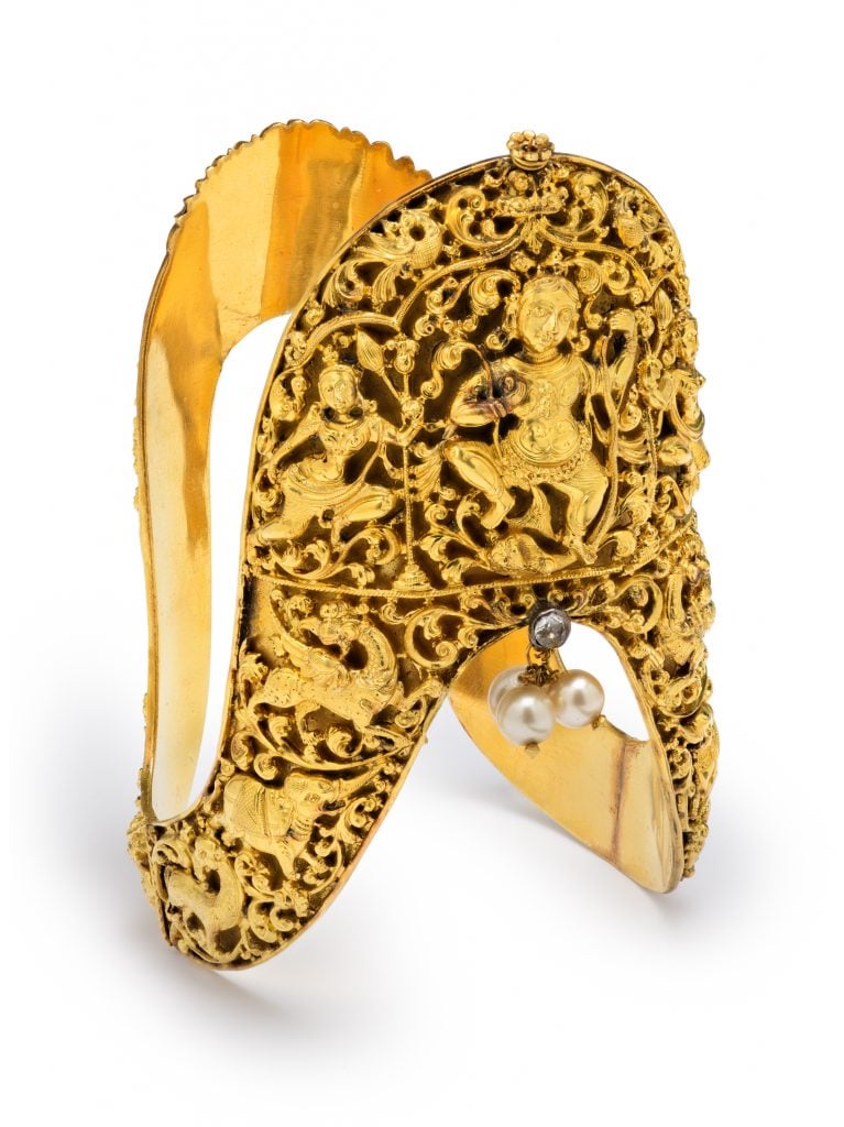 Armlet with Krishna overcoming the serpent Kaliya (ca. 1850–1900). India; Chennai, Tamil Nadu state. Gold, opalescent glass, and topaz. Collection of the Los Angeles County Museum of Art, purchased with funds provided by the Nasli and Alice Heeramaneck Collection, Museum Associates Purchase.