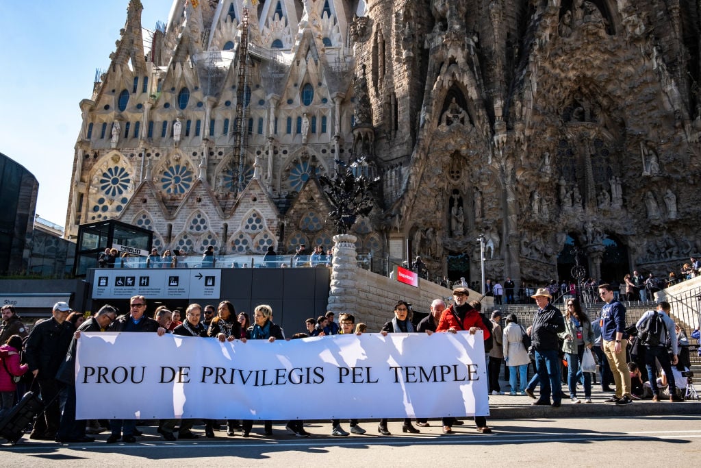 Neighbors affected by the construction of the Sagrada Familia protest with a banner in front of the landmark during a demonstration in 2016. Photo by Paco Freire/SOPA Images/LightRocket via Getty Images.