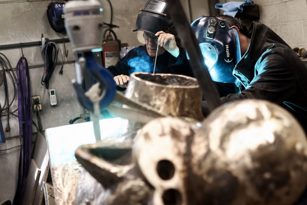Belgian cartoonist Philippe Geluck (L) works at the foundry 