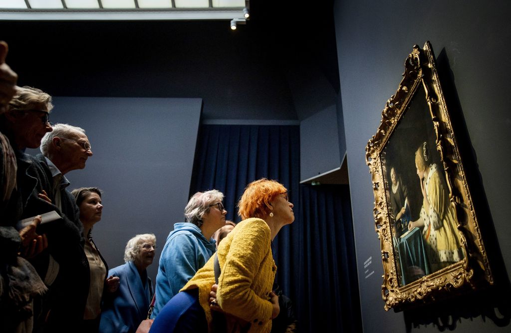 Visitors look at the painting 