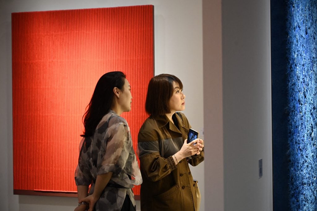 Visitors look at an artwork by South Korean artist Park Seo Bo at Art Basel in Hong Kong on March 21, 2023. Photo: PETER PARKS/AFP via Getty Images.