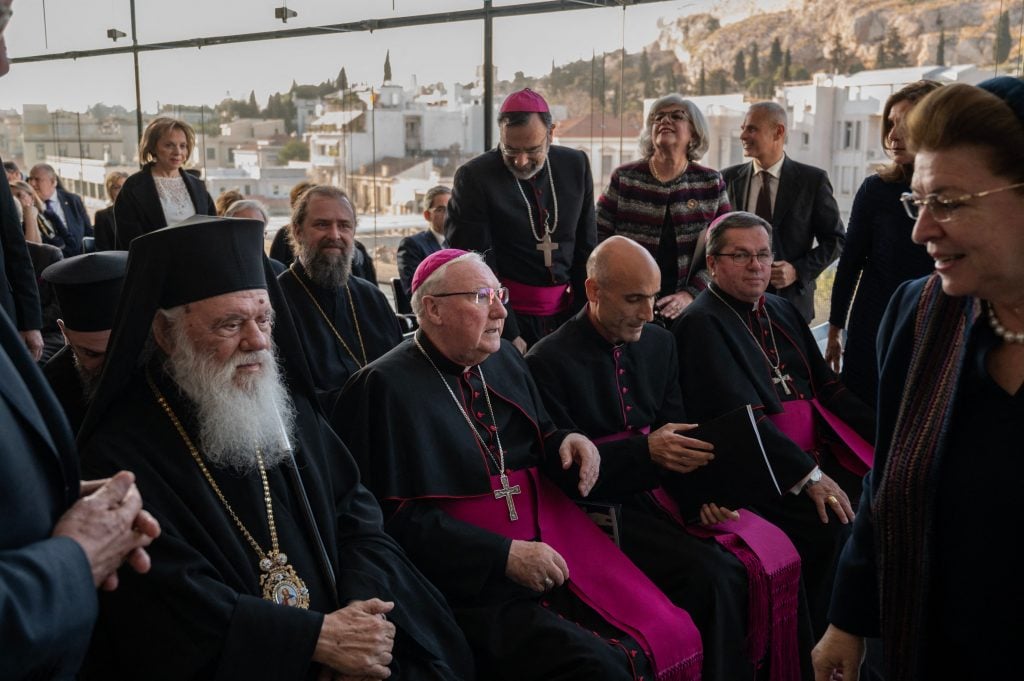 Bishop Brian Farrell, a Vatican secretary for promoting Christian unity (C) and Greece's Orthodox Church Archbishop Ieronymos (L) attend a ceremony at the Acropolis Museum in Athens for the repatriation of three fragments from the Parthenon marbles. Photo by Angelos Tzortzinis/AFP via Getty Images.