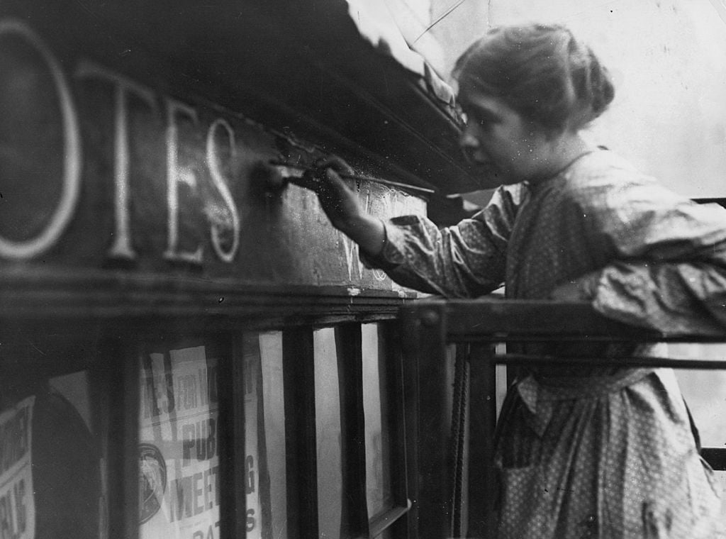 11th October 1912: English suffragette Estelle Sylvia Pankhurst, (1882 - 1960), daughter of Emmeline and sister of Christabel Pankhurst, at work on the facia of the Women's Social Defence League shop in Bow Street, London. Photo by Hulton Archive/Getty Images.