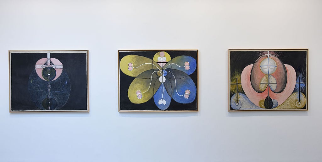 a series of paintings hanging on a white wall