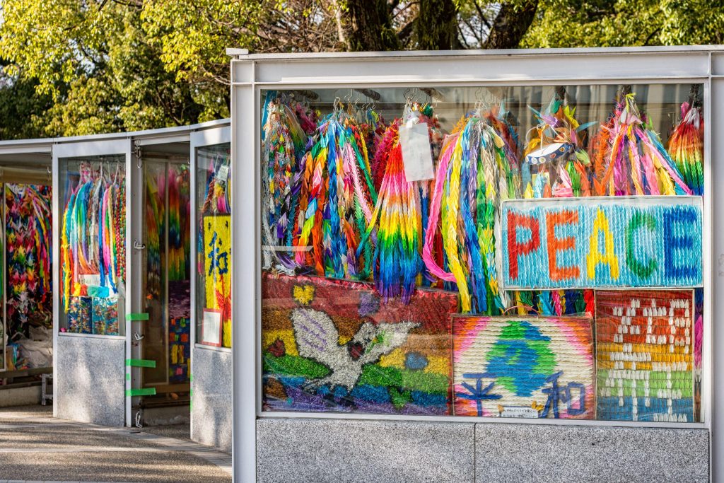 Hiroshima / Japan - December 21, 2017: Brightly colored paper cranes at the Children's Peace Monument to commemorate Sadako Sasaki and thousands of children victims of the atomic bombing of Hiroshima. ©︎ Mirko Kuzmanovic and Alamy Stock Photo.