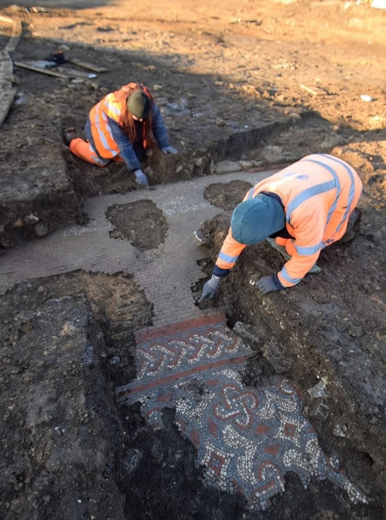 Members of the OA team cleaning the mosaic. Photo courtesy of Oxford Archaeology.
