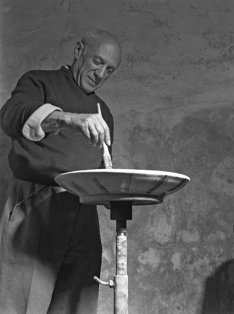 Spanish artist Pablo Picasso decorates one of his ceramic dishes, Paris, 1948. Photo by Archivio Cameraphoto Epoche/Getty Images.