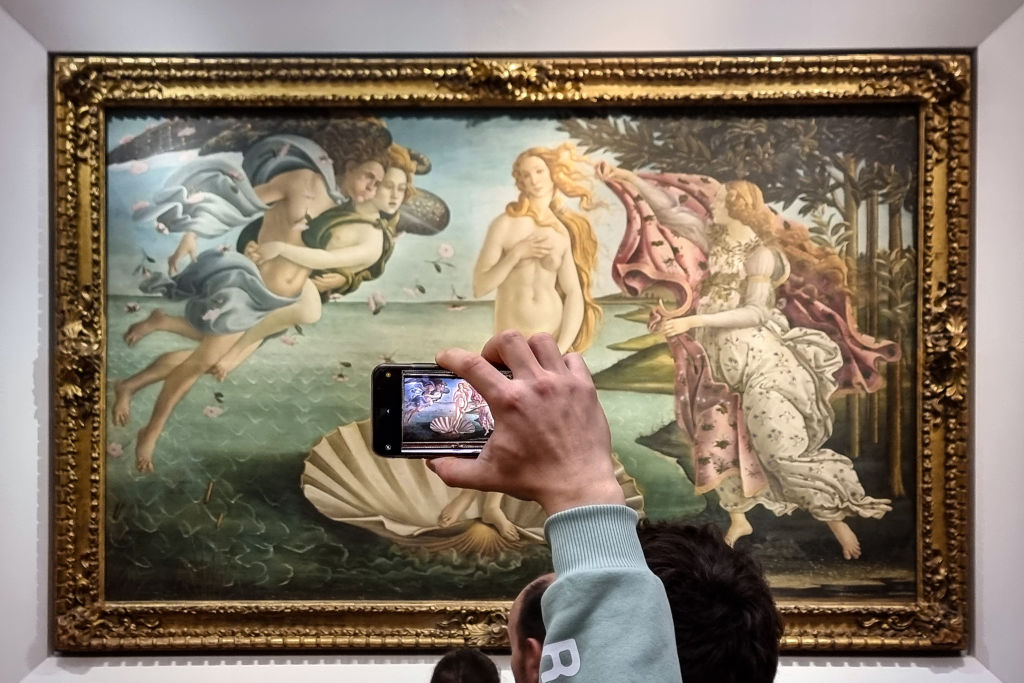 A visitor photographs Sandro Botticelli's Birth of Venus at the Uffizi Galleries. Photo by David Silverman/Getty Images.