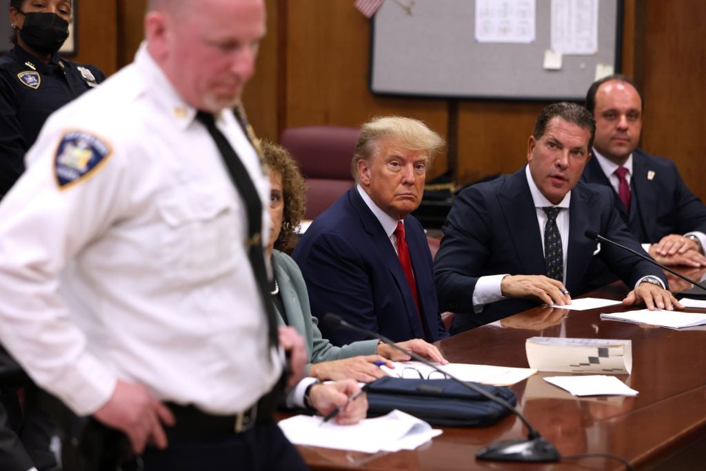 Former U.S. President Donald Trump sits with his attorneys inside the courtroom during his arraignment at the Manhattan Criminal Court April 4, 2023 in New York City. Trump pleaded not guilty to 34 felony counts stemming from hush money payments made to adult film star Stormy Daniels before the 2016 presidential election. Photo by Andrew Kelly-Pool/Getty Images.