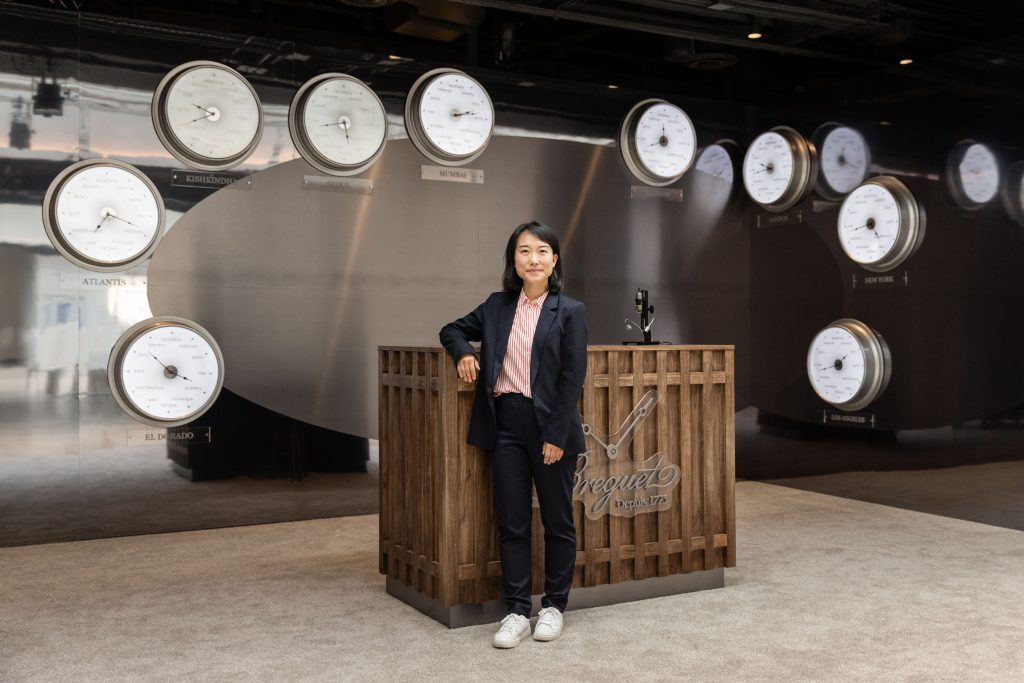 Somi Sim stands in front of Raqs Media Collective's “I Fall in Love Out of Orbit” on the opening day of Frieze New York. Courtesy of Breguet. 