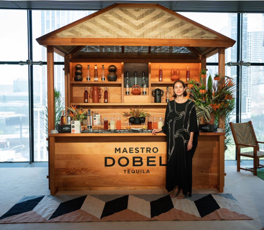 Marissa Naval stands next to the custom bar she designed. Courtesy of Maestro Dobel. 
