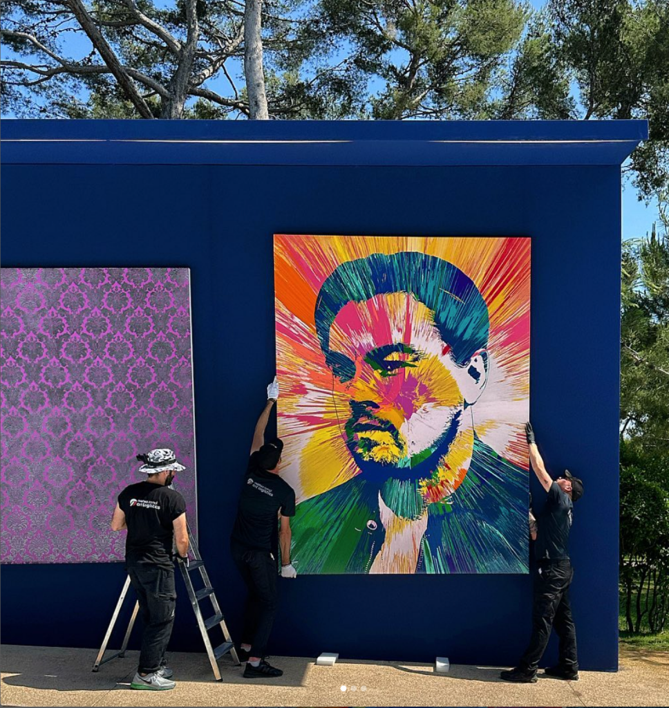 Damien Hirst's painting of Leonardo DiCaprio being installed at the amfAR gala in Cannes. Courtesy Simon de Pury.