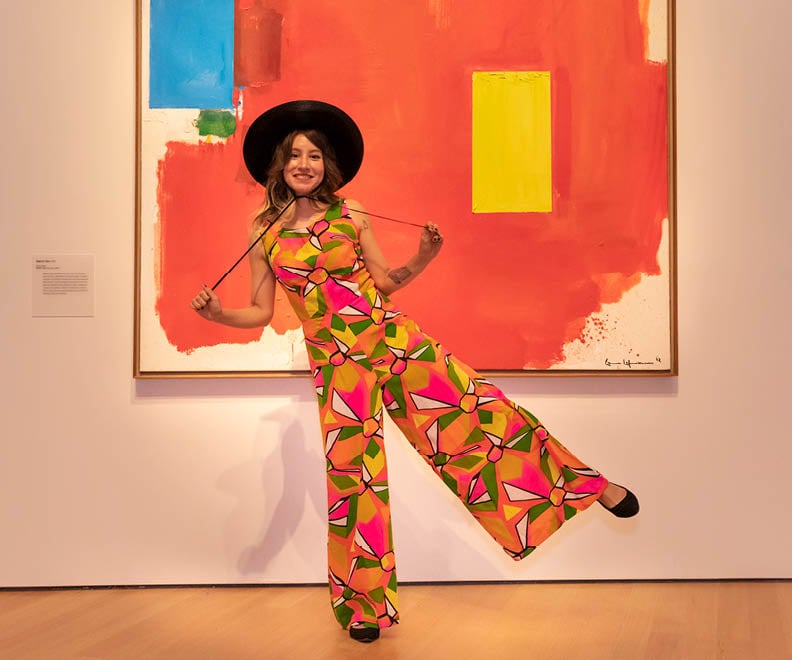 A woman poses with a painting at the Peabody Essex Museum. Photo courtesy of the Peabody Essex Museum, Salem, Massachusetts.