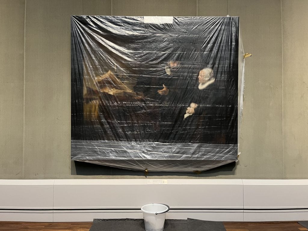 Rembrandt van Rijn’s The Mennonite preacher Cornelis Claesz Anslo and his wife Aeltje Gerritsdr Schouten (1641) covered with plastic to protect the painting from the leaking ceiling at the Gemäldegalerie, Staatliche Museen zu Berlin. Photo by David Grubbs.