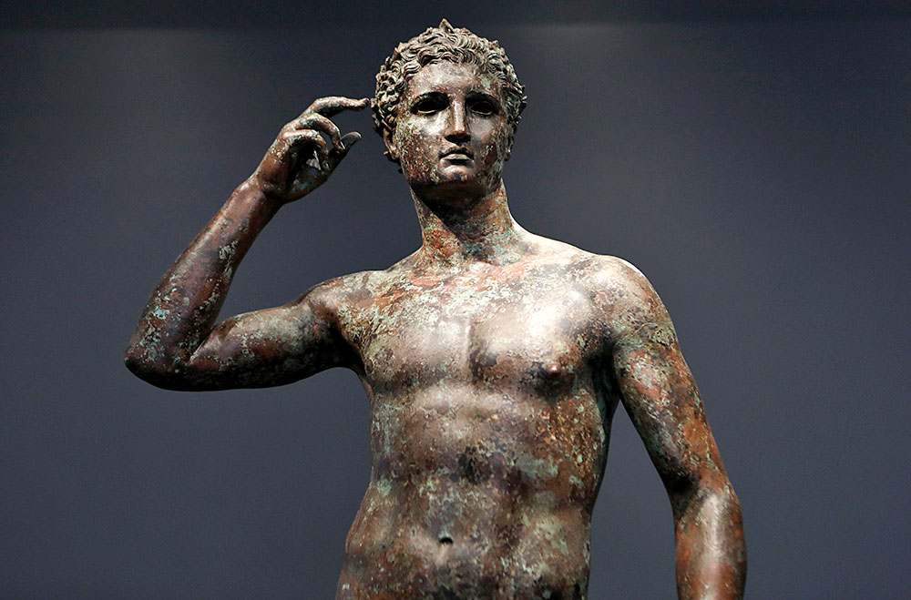 The statue known as <em>Victorious Youth</em> is displayed at the Getty Villa. (Photo by Mario Tama/Getty Images)