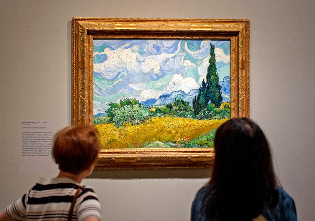 Visitors look at a painting during a preview of "Van Gogh's Cypresses" exhibition at the Metropolitan Museum of Art on May 15, 2023, in New York City. Photo: Wang Fan/China News Service/VCG via Getty Images.