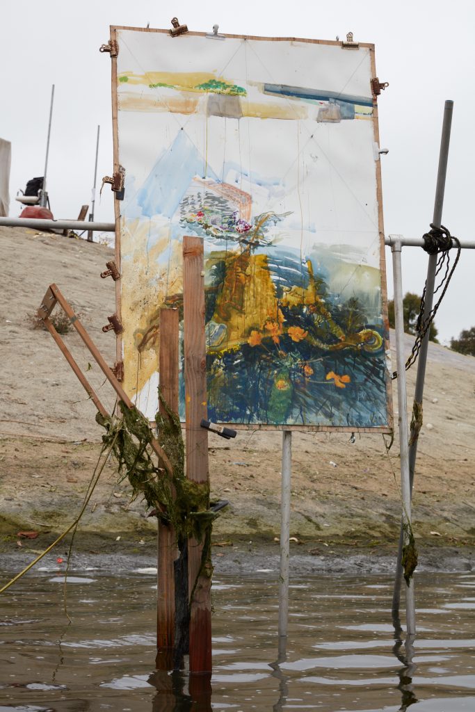A Sterling Wells painting being created on a floating easel in Ballona Creek, Los Angeles. Photo by Nik Massey, courtesy of Night Gallery, Los Angeles.