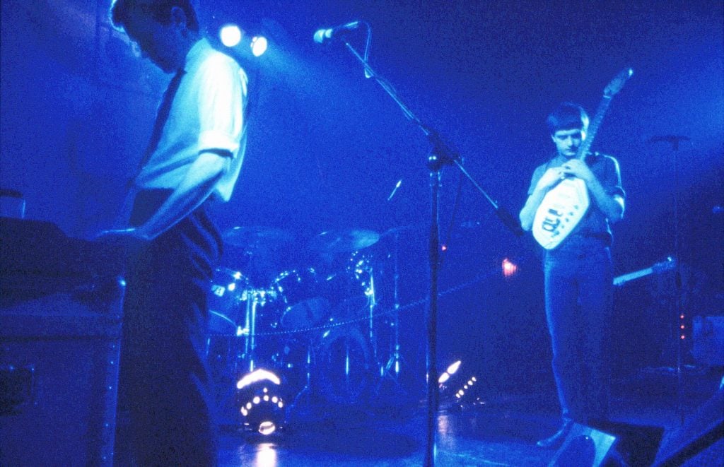 Lyceum photo of Bernard Sumner (L) and Ian Curtis (R) of Joy Division performing live onstage. (Photo by Chris Mills/Redferns)