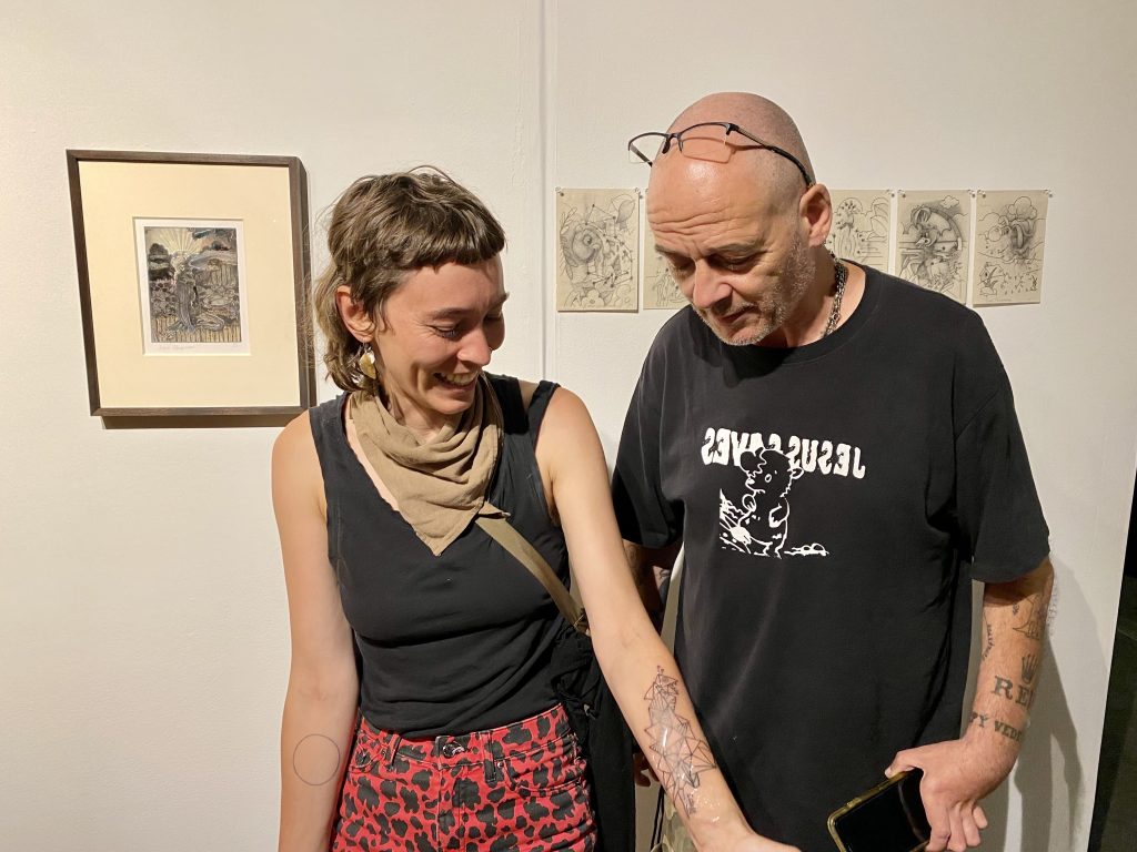 Kate Lovejoy sees her tattoo designed by Dinos Chapman for the first time at the Seattle Art Fair. Photo by Sarah Cascone.