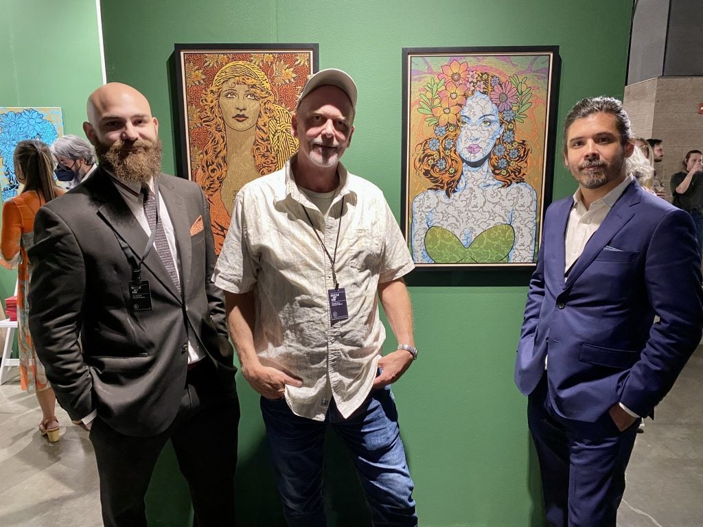 Gallery director Raul Barquet, artist Chuck Sperry, and gallery owner Ken Harman at the booth of New York's Harmon Gallery at the Seattle Art Fair. Photo by Sarah Cascone.