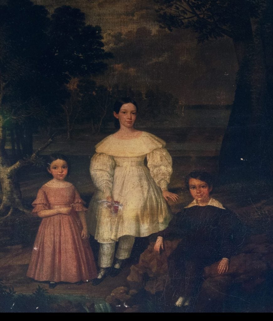 Attributed to Jacques Guillaume Lucein Amans,<em>Bélizaire and the Frey Children</em> (ca. 1837) before it was restored, with the ghostly outline of the figure of an enslaved boy visible behind the white children. Photo courtesy of Christie’s New York.” width=”871″ height=”1024″  ></p>
<p id=