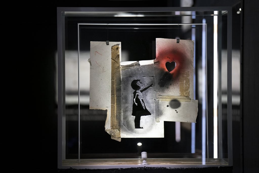 The original stencil piece for Banksy's <em>Girl With Balloon</eM>, which infamously shredded itself after selling at auction at Sotheby's London on display in "Banksy: Cut and Run" at Glasgow's Gallery of Modern Art. Photo by Jane Barlow/PA Images via Getty Images.