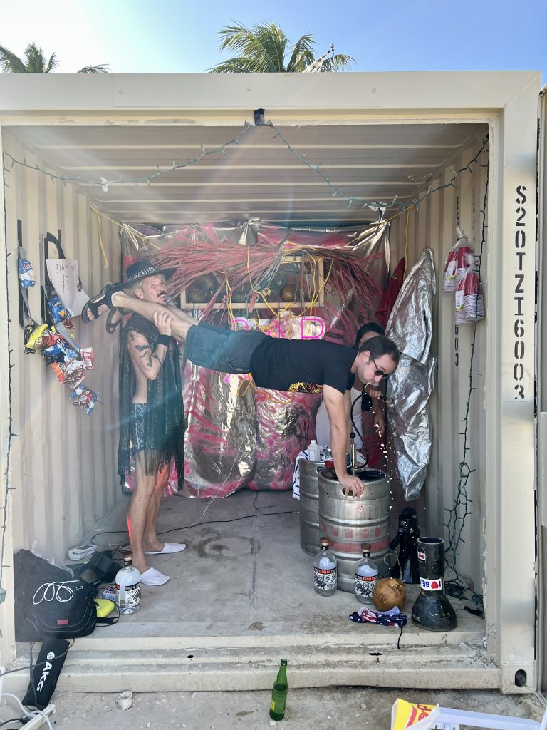 Founder Brian Whiteley helps a guest do a keg stand at the 2022 Satellite Art Show in Miami Beach. Photo by Wesley Hevia. 