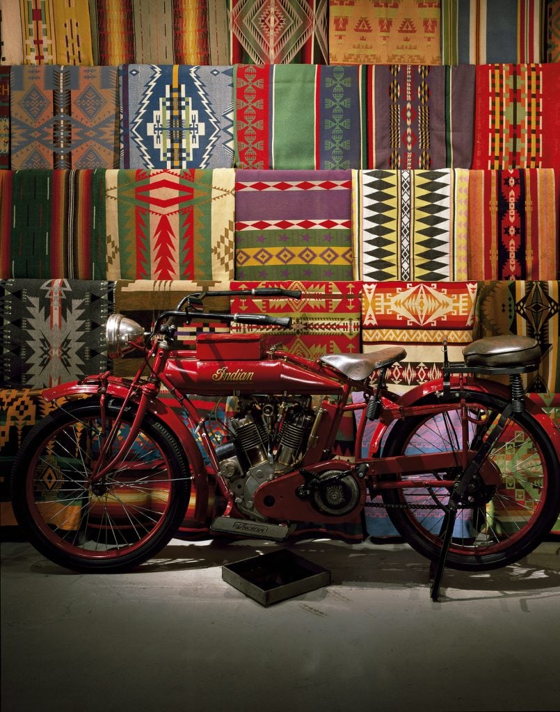 Pendleton blankets and a 1914 Indian Motorcycle in the Northwest Room at the Boathouse, Dale Chihuly's Seattle studio. Photo by Nathaniel Willson, ©2023 Chihuly Studio.