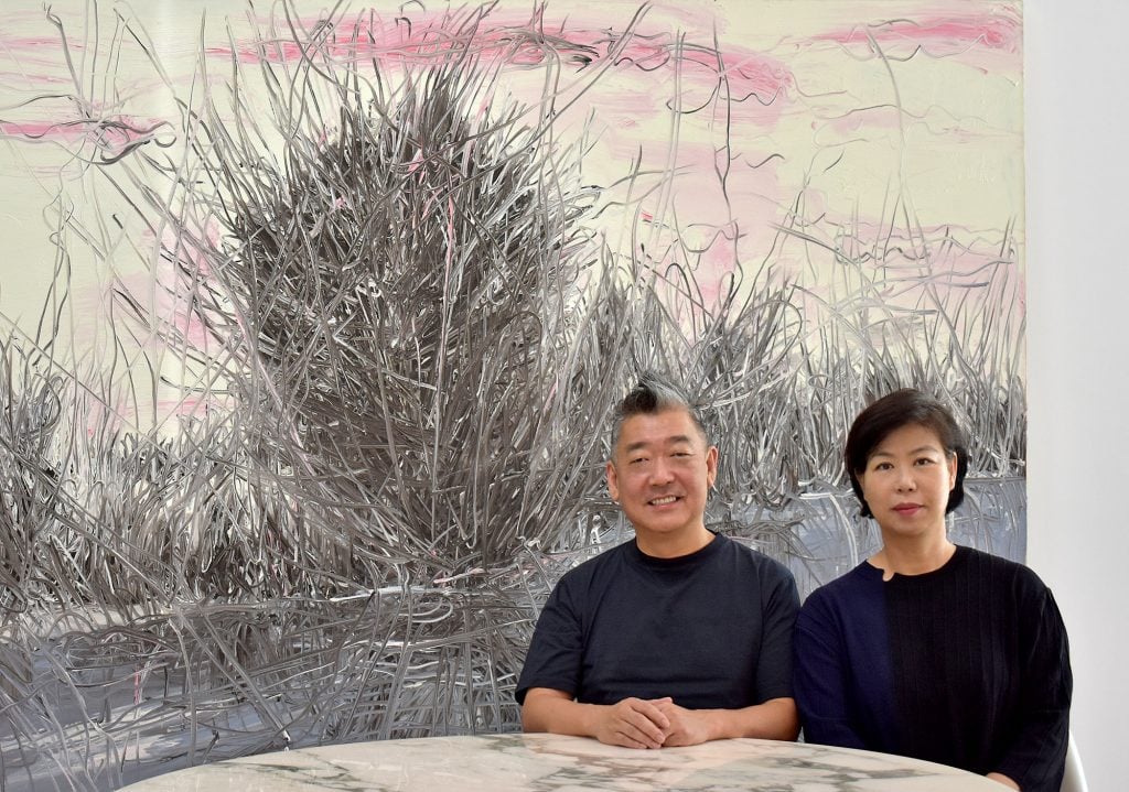 Jung Lee and Jeeyoon Lim with Country Side No. 7 (2004) by Zeng Fanzhi. Courtesy of the collectors.