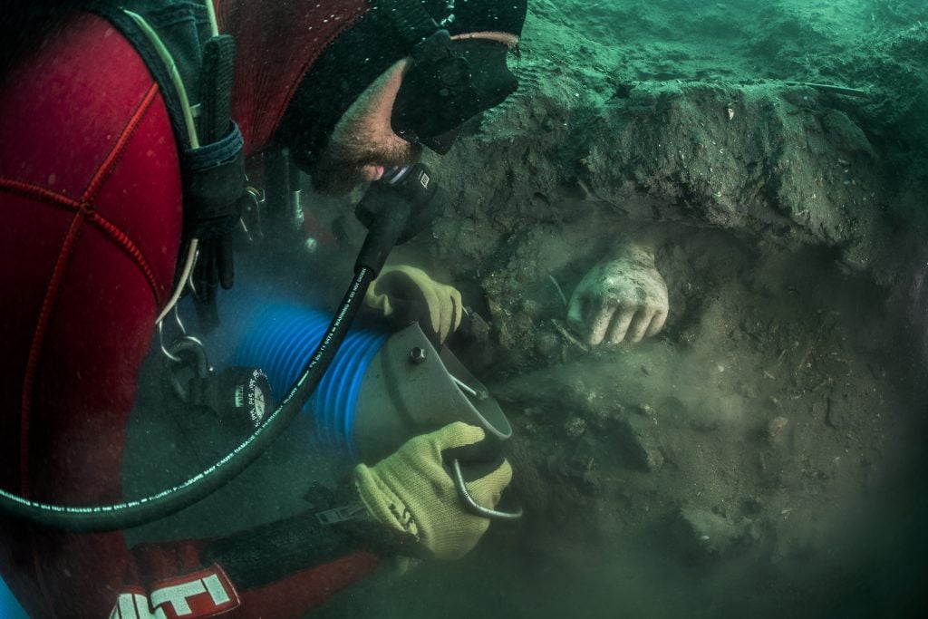 A votive hand is emerging from the sediment during an archaeological excavation in Thonis-Heracleion. End of 5th century B.C.E.-early 4th century B.C.E., probably from Cyprus. Photo by Christoph Gerigk, ©Franck Goddio/Hilti Foundation.