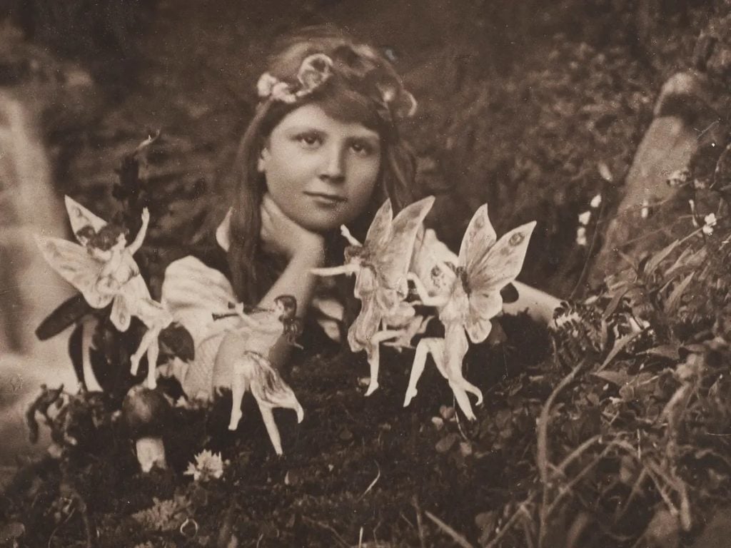 The first of the Cottingley Fairy photographs from 1917, taken by Elsie Wright and showing Frances Griffiths ringed by "fairies."