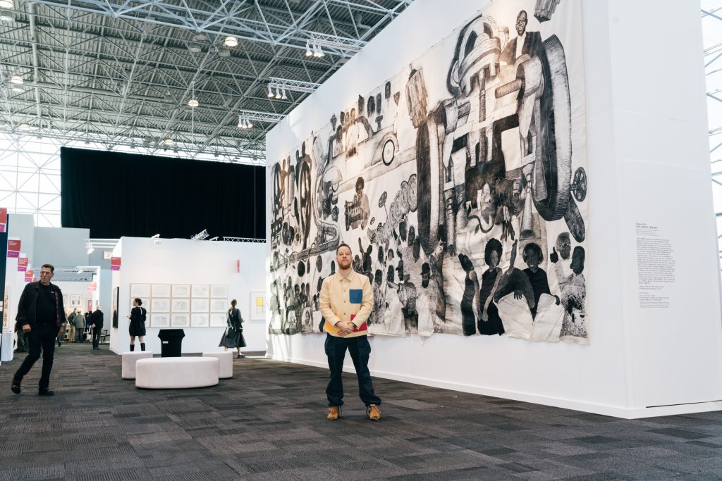 Yashua Klos with <em>Our Labor</em> (2020–21) at the IFPDA Print Fair 2023. Photo by Annie Forrest.