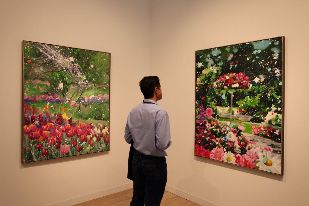 A visitor looks at "Garden of Expression" and "Beautiful Garden" by Damien Hirst at Frieze Masters Art Fair in Regent's Park in London on October 11, 2023. Photo by DANIEL LEAL/AFP via Getty Images.