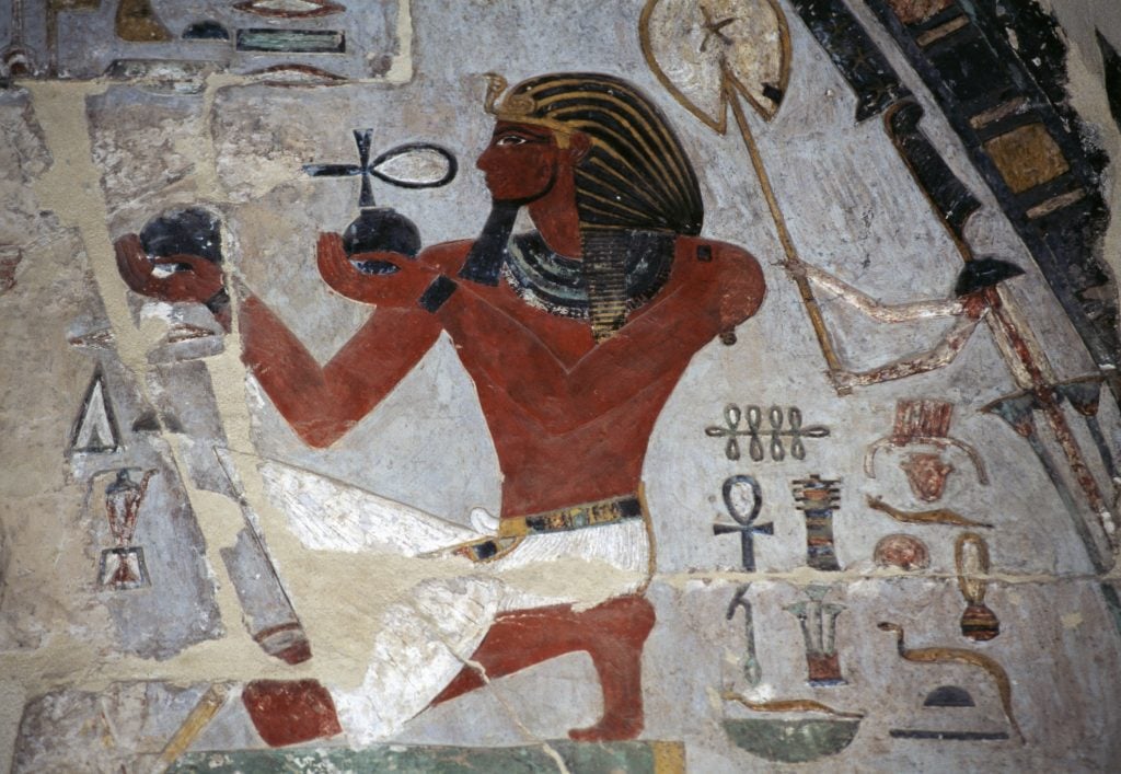 An ancient egyptian wall painting depicts a pharaoah offering wine