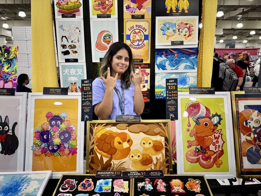 Nicole Sands with her work at 2023 New York Comic Con. Photo by Sarah Cascone. 