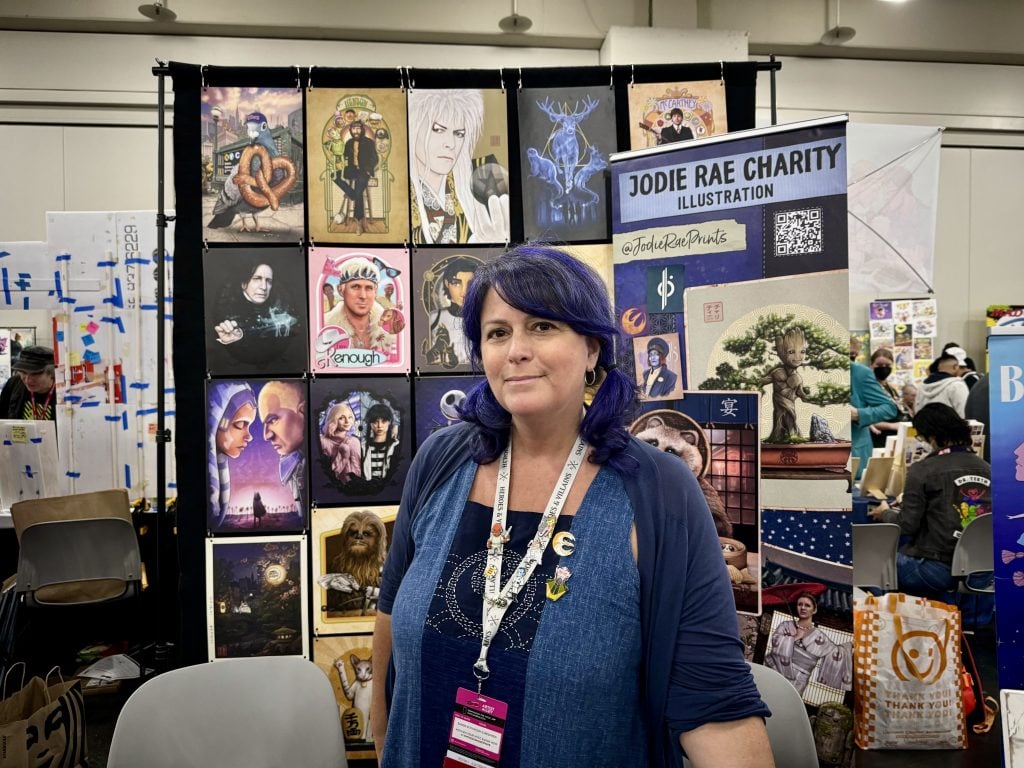 Jodie Rae Charity with her work at 2023 New York Comic Con. Photo by Sarah Cascone. 
