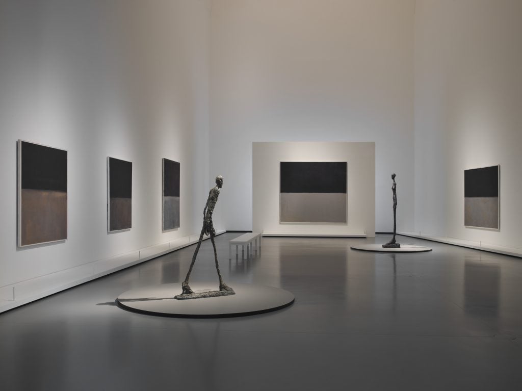 Left to right: Mark Rothko, <i>Untitled</i> (1969-1970), <i>Untitled</i> (1969), <i>Untitled</i> (1969), <i>Untitled</i> (1969), <i>Untitled</i> (1969). Sculptures : Alberto Giacometti L’Homme qui marche I, 1960 Grande Femme III, 1960 Vue d'installation de l'exposition Mark Rothko, galerie 10, niveau 2, salle Black and Gray, Giacometti, exposition présentée du 18 octobre 2023 au 2 avril 2024 à la Fondation Louis Vuitton, Paris. © 1998 Kate Rothko Prizel & Christopher Rothko - Adagp, Paris, 2023