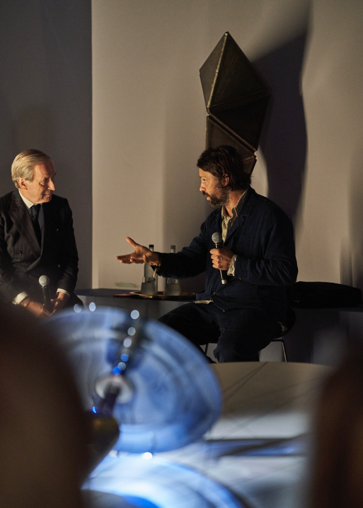 Veteran auctioneer and Artnet News contributor Simon de Pury (left) speaking with Conrad Shawcross (right) about the artist's sculpture. Photo: Danny J. Peace. Courtesy of Royal Salute.