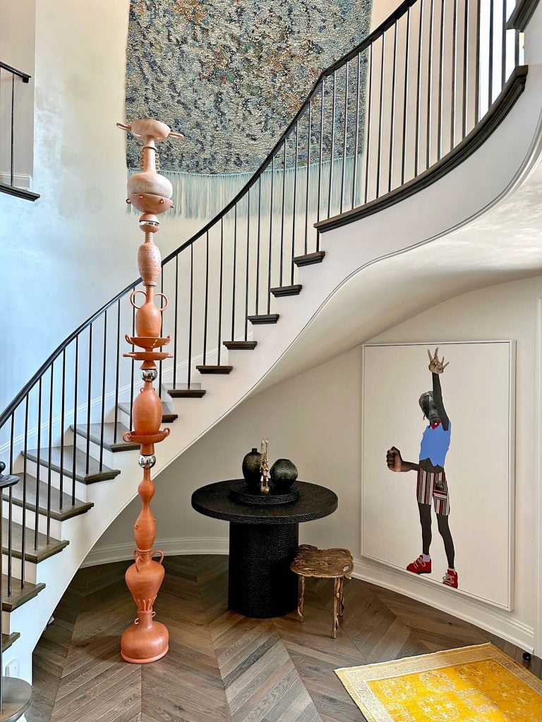 At the top of the staircase hangs Igshaan Adams's <em>Die Son Bêre Sy Hitte Ondergronds (the sun stores its heat underground)</em> (2022). Ceramic sculpture by Cammie Staros. Deborah Roberts, <em>Let's not give up</em> (2020), lower right. Courtesy of Pete Scantland.