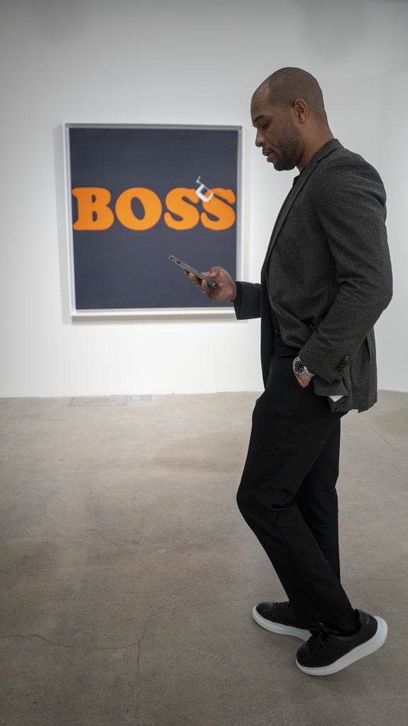 Musa with Ed Ruscha''s <i>Securing the last letter (Boss)</i> at Sotheby's. Courtesy of Jayden Bempong.